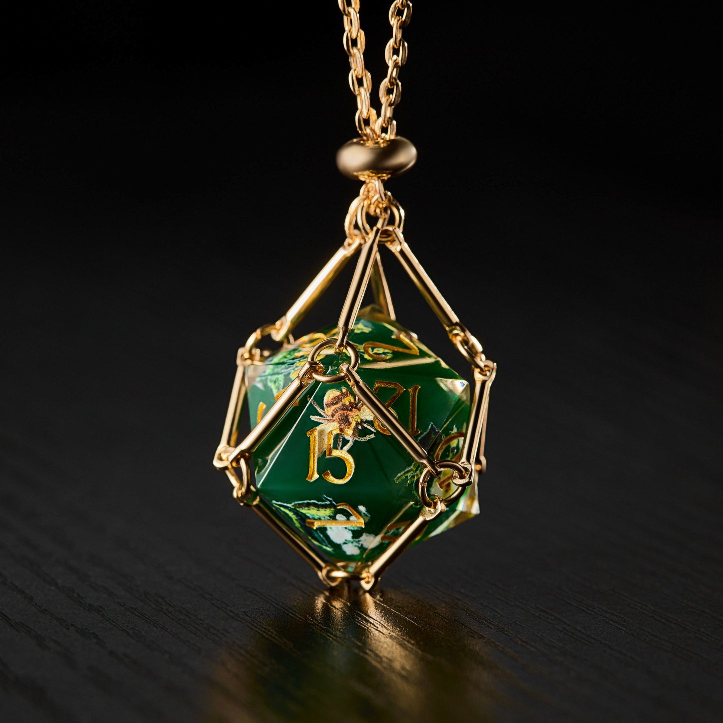 a golden necklace with a green dice on it