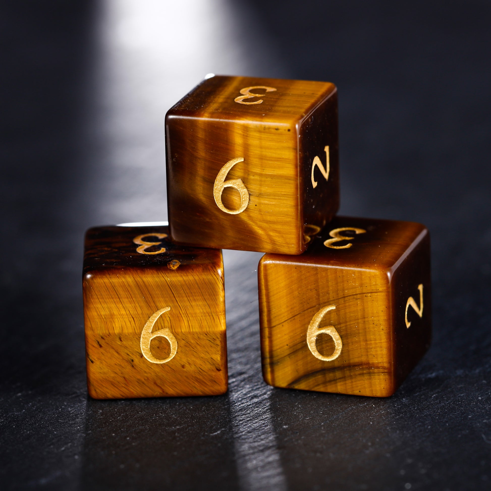 three wooden dices with gold numbers on them