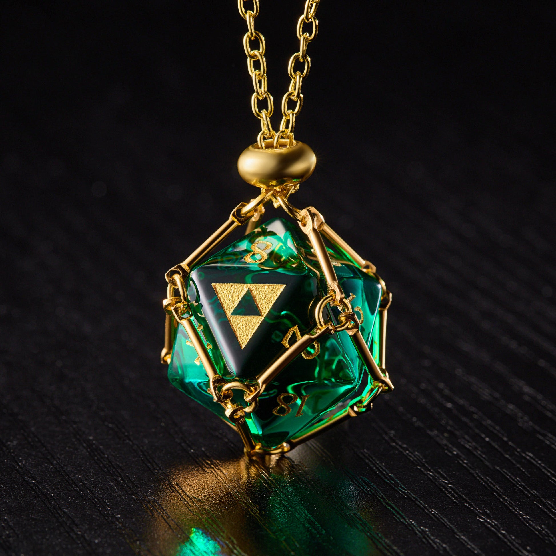 a green and gold necklace with a diamond on it