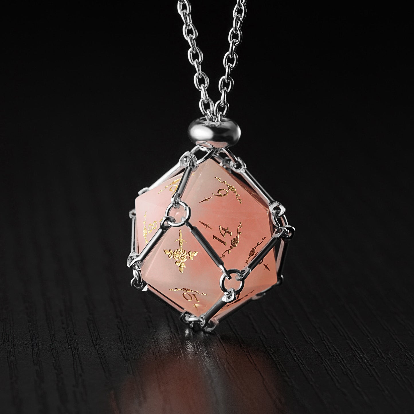 a pink and silver necklace on a black surface