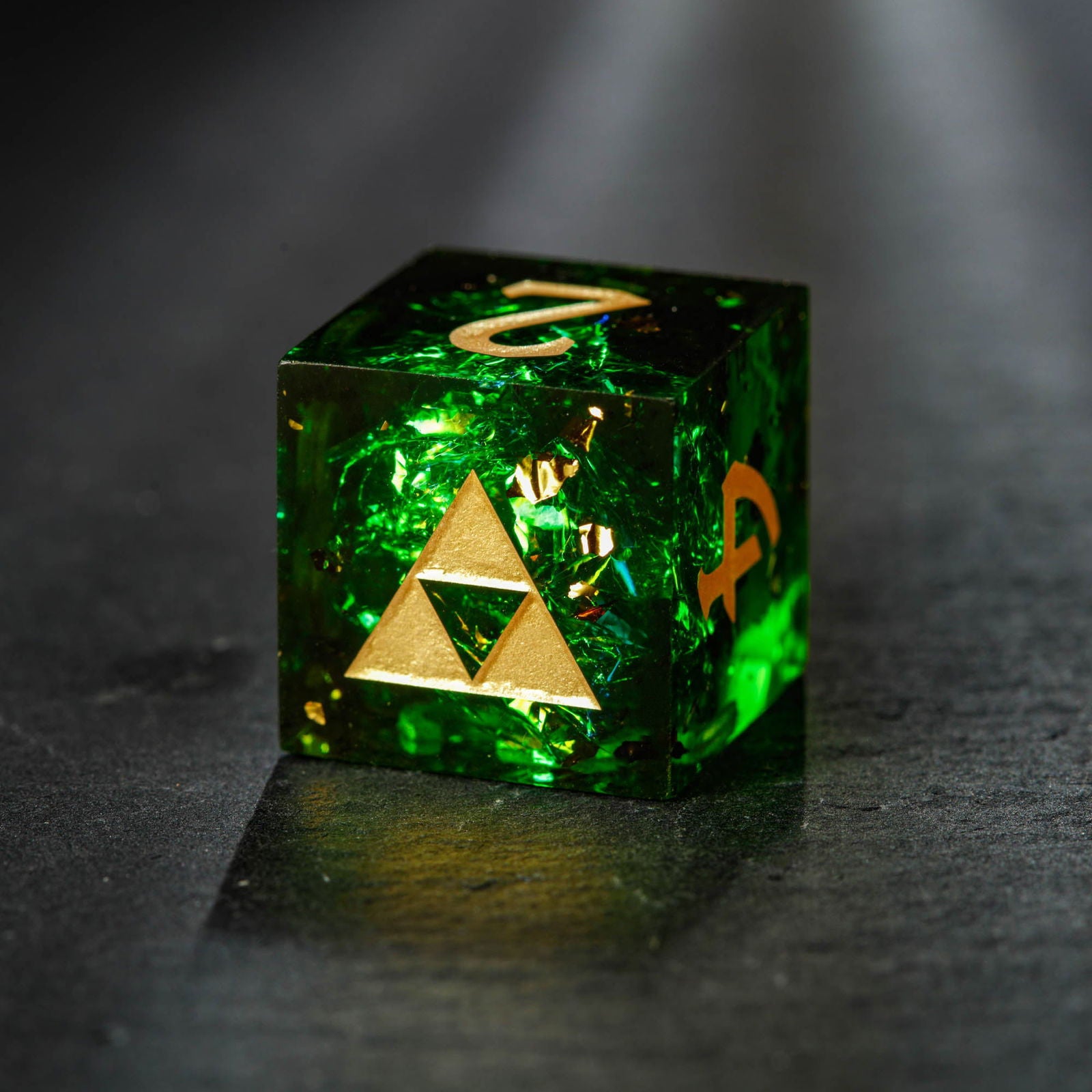 Close-up of dark green glitter resin D20 die with sharp edges