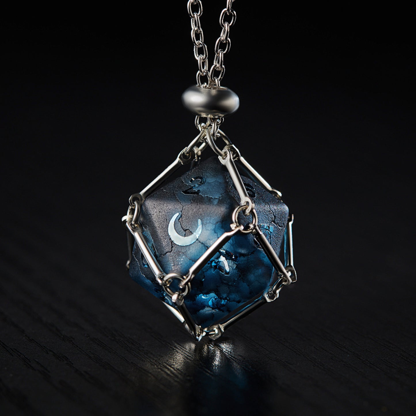 a blue and silver necklace with a moon on it