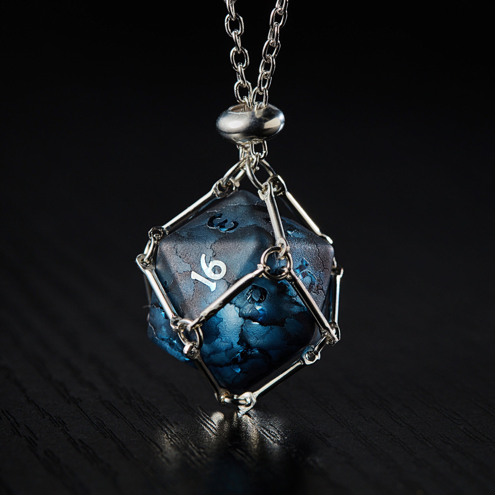 a necklace with a blue and black cube on a chain