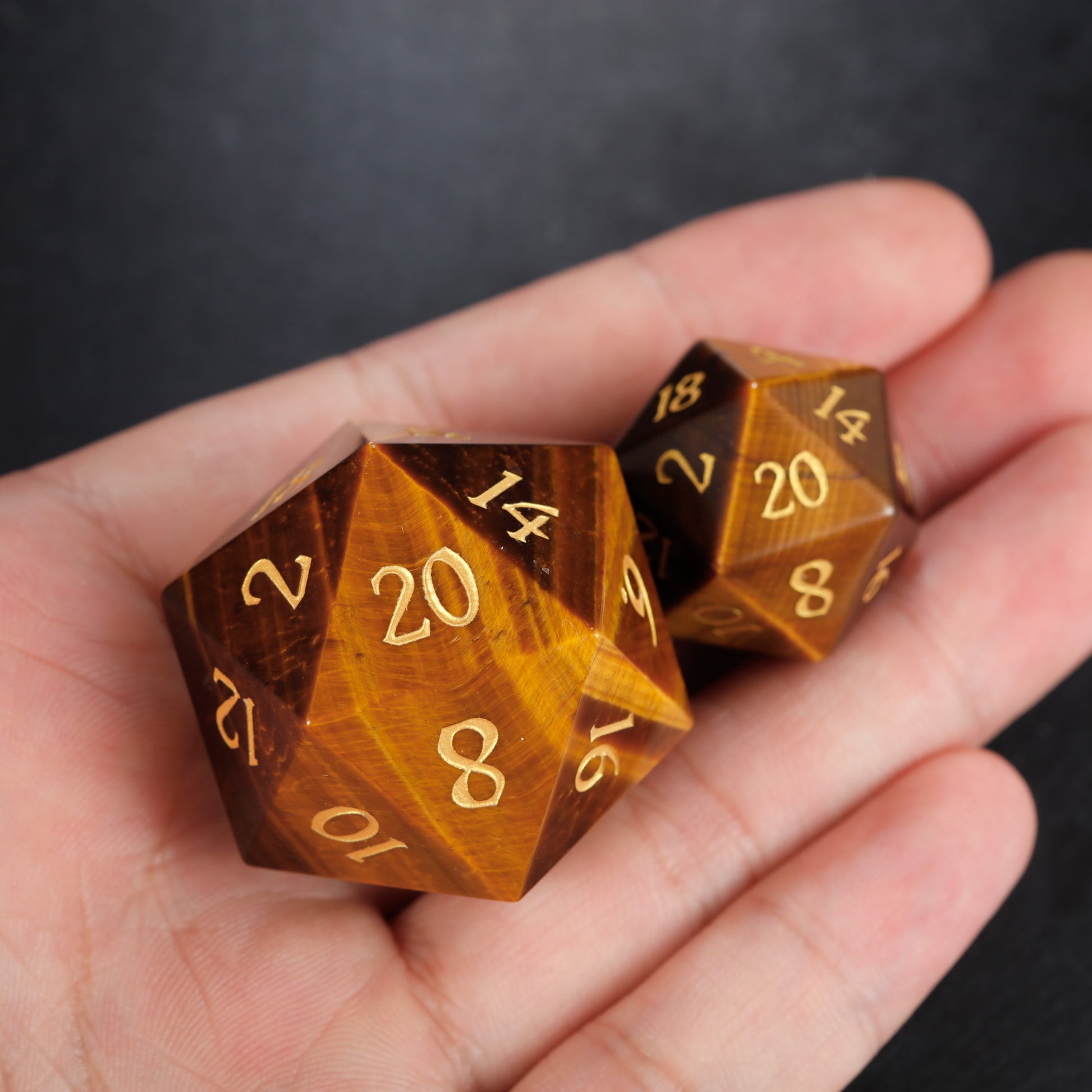 a hand holding two brown dices with numbers on them