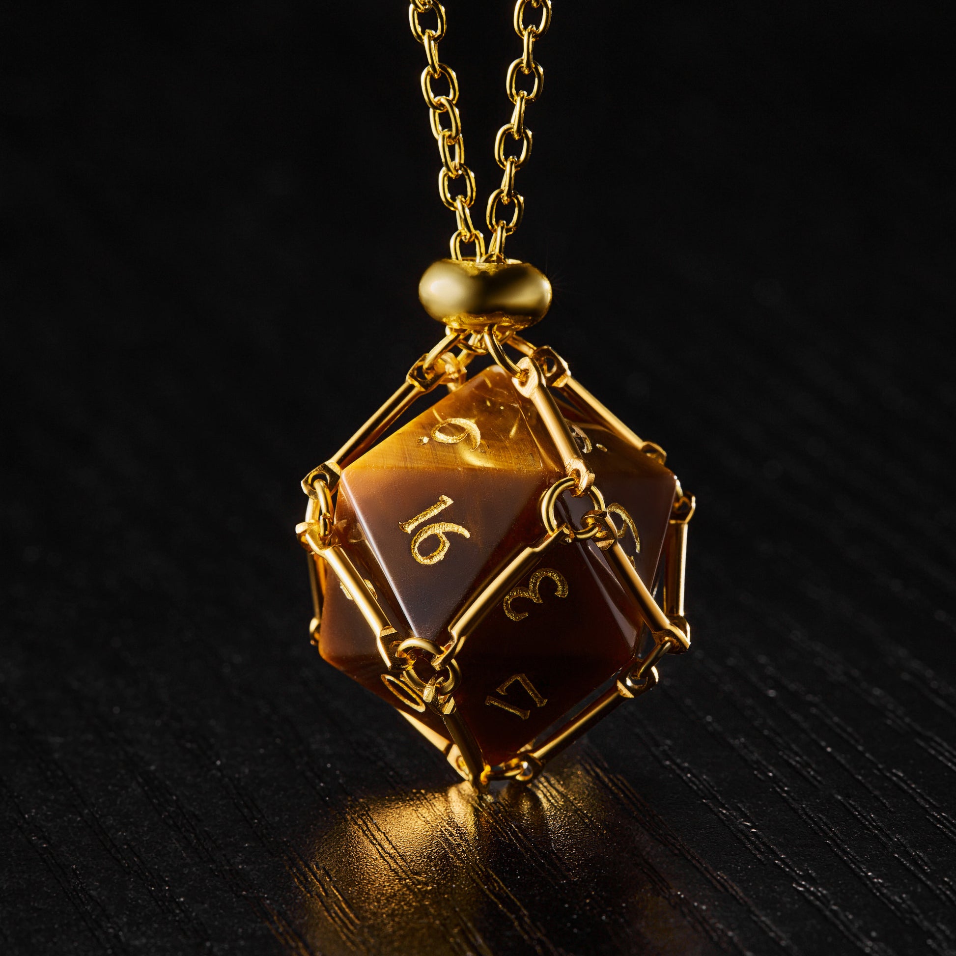 a gold necklace with a brown dice on it