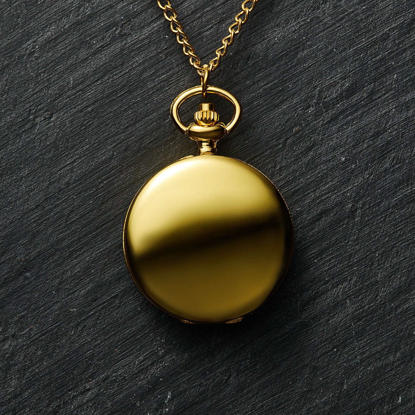a gold pocket watch on a gold chain