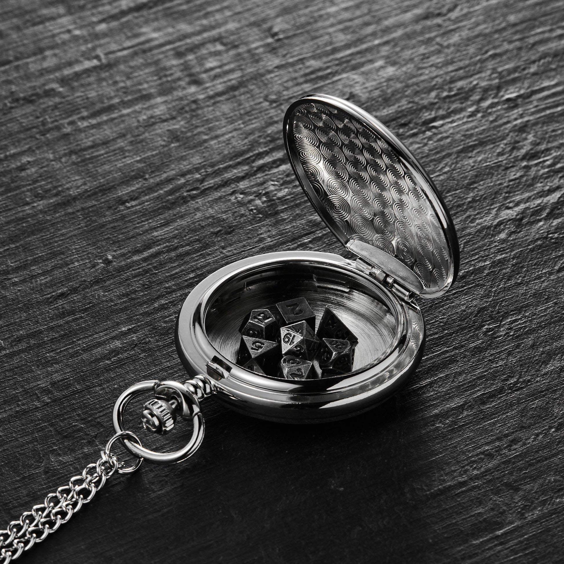 a pocket watch with dice in it on a table